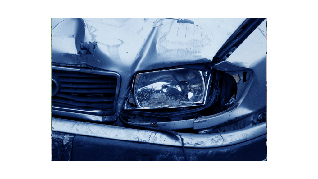 Damaged vehicle front with crumpled hood and broken headlight, illustrating collision impact relevant to auto body repair and insurance claims.