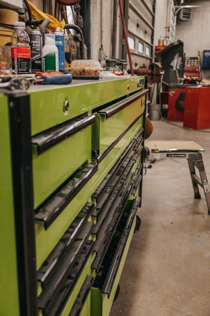Green tool chest in auto body repair shop with various tools and supplies, emphasizing the equipment used for collision repair services at Lititz Collision.