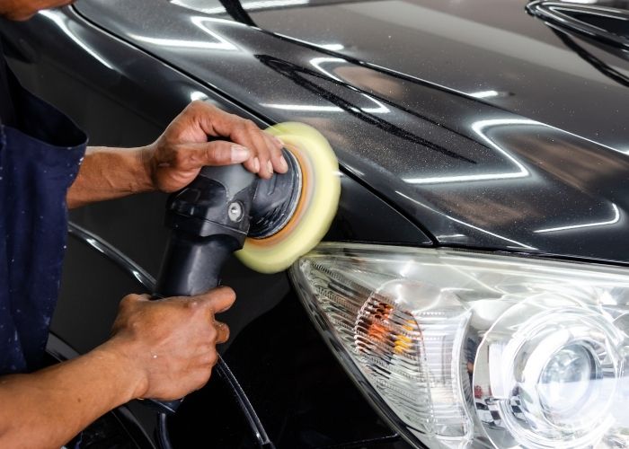 man buffing the car hood and headlight