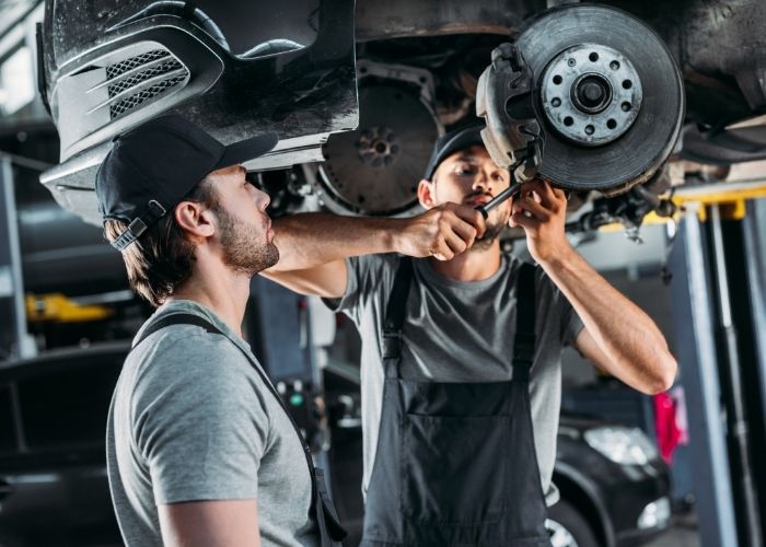 two men fixing car wheel