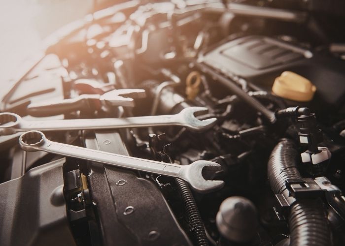 Close-up of a car engine with wrenches and tools, showcasing intricate mechanical details relevant to auto repair and collision services at Lititz Collision in Annville.